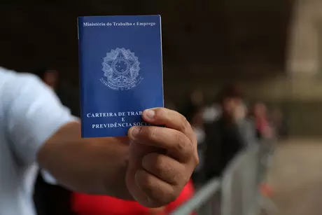 Homem mostra carteira de trabalho em fila para buscar vagas de emprego, em São Paulo 29/03/2019 REUTERS/Amanda Perobelli