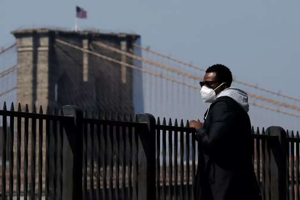 Homem usa máscara ao caminhar no Brooklyn, em Nova York, neste domingo (19) — Foto: Andrew Kelly/Reuters