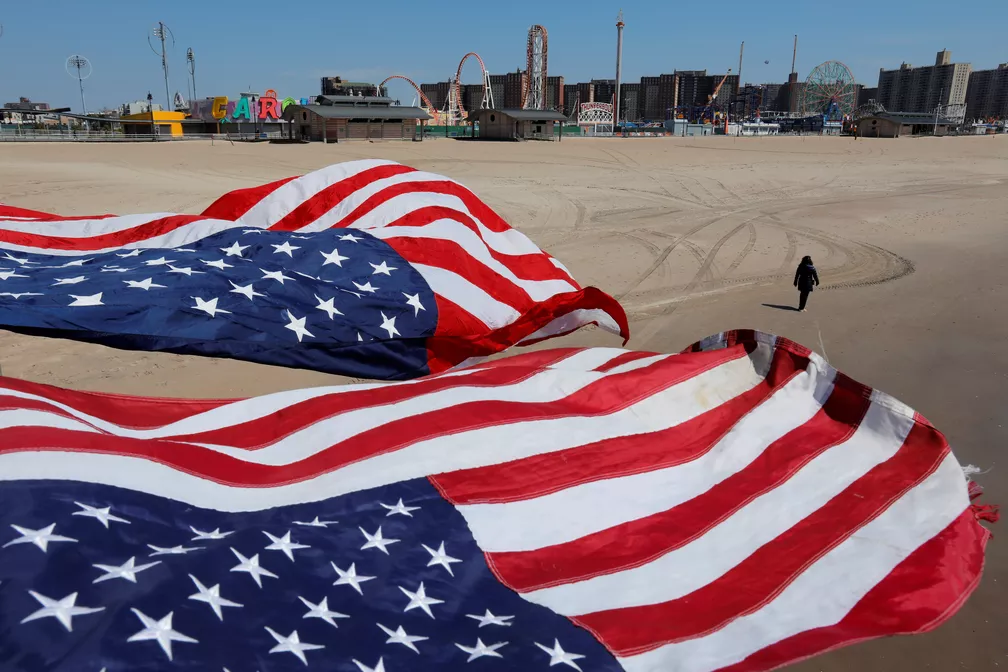 Bandeiras dos EUA em praia de Coney Island, em Nova York, neste domingo (19) — Foto: Andrew Kelly/Reuters