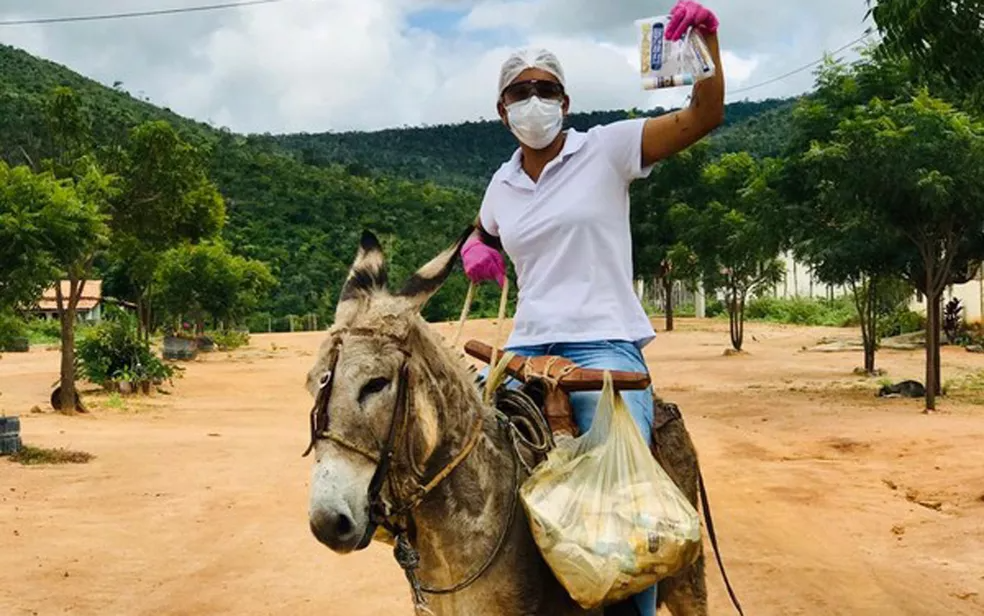 Monaliza montada no jegue para atender as famílias na área rural de Boa Vista do Tupim — Foto: Monaliza Oliveira/Arquivo Pessoal