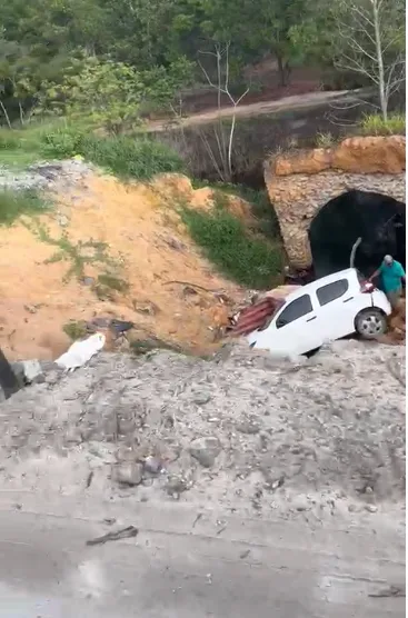 Carro cai em cratera aberta pela chuva na BR 418 em Caravelas