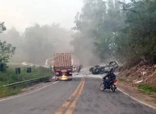 Carreta carregada com sacos de cimento capota e espalha carga na BR-101, em Itabela